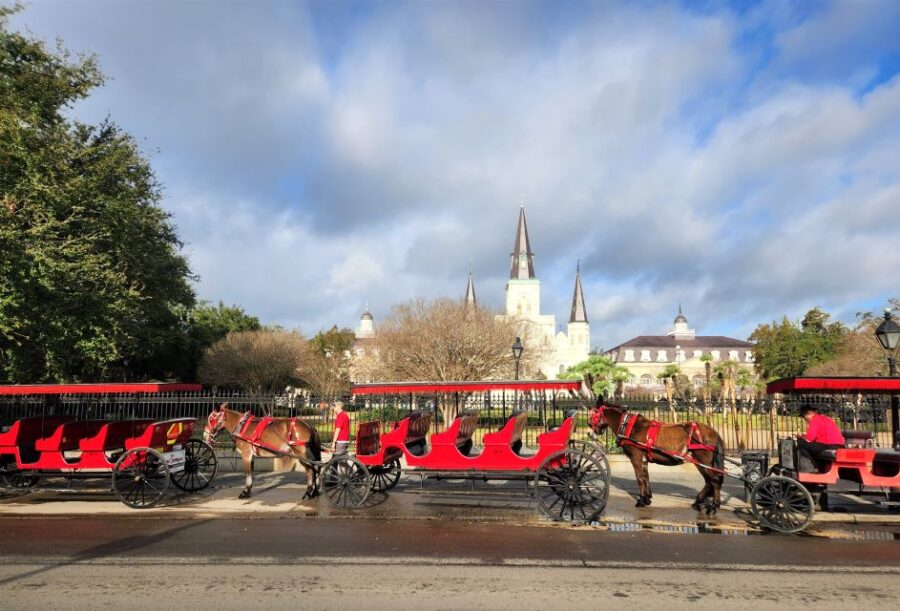 Image of horse drawn carriages outside The St. Louis Cathedral in New Orleans.